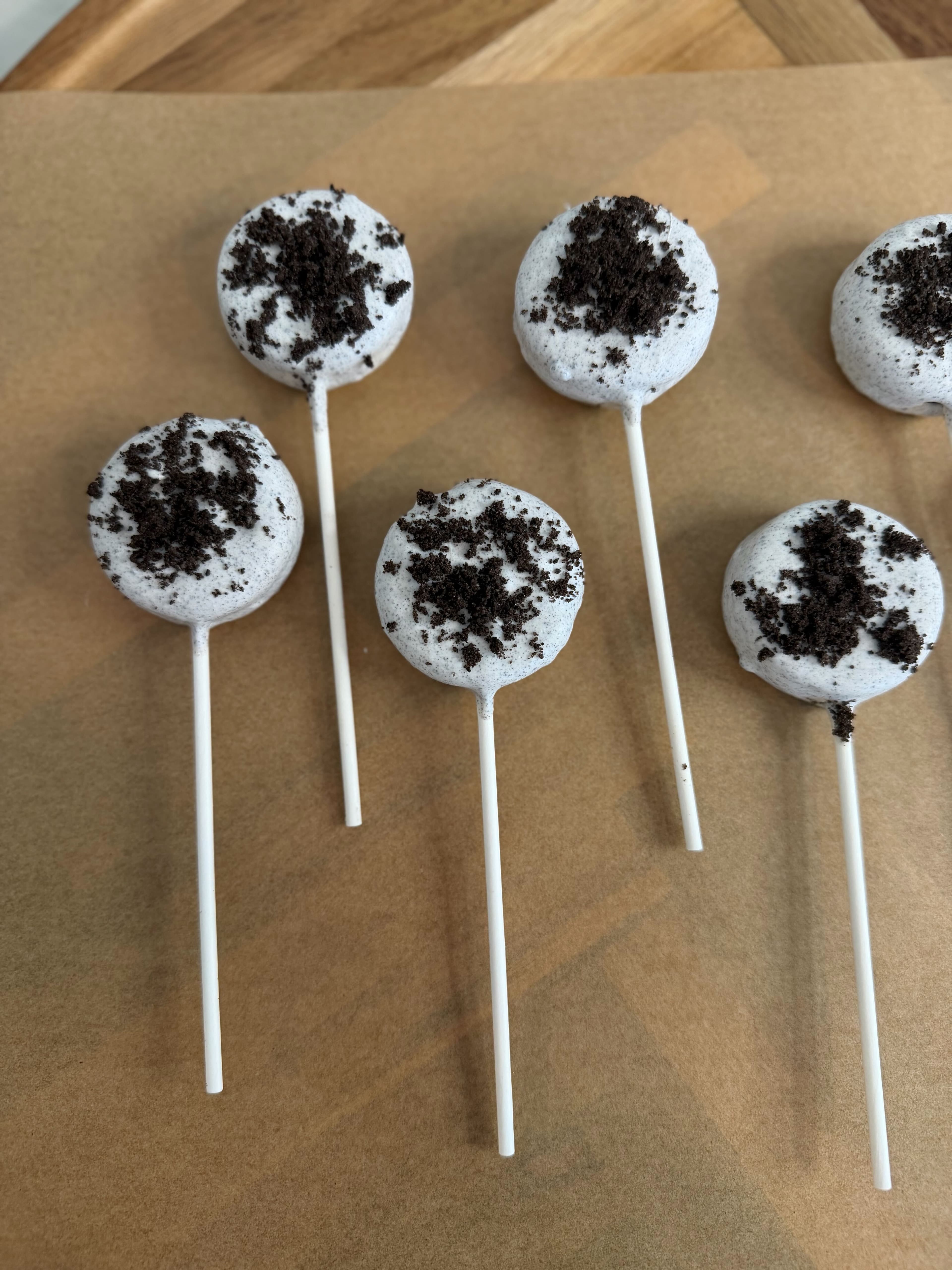Cake pops with creamy frosting base and crushed cookie crumb topping