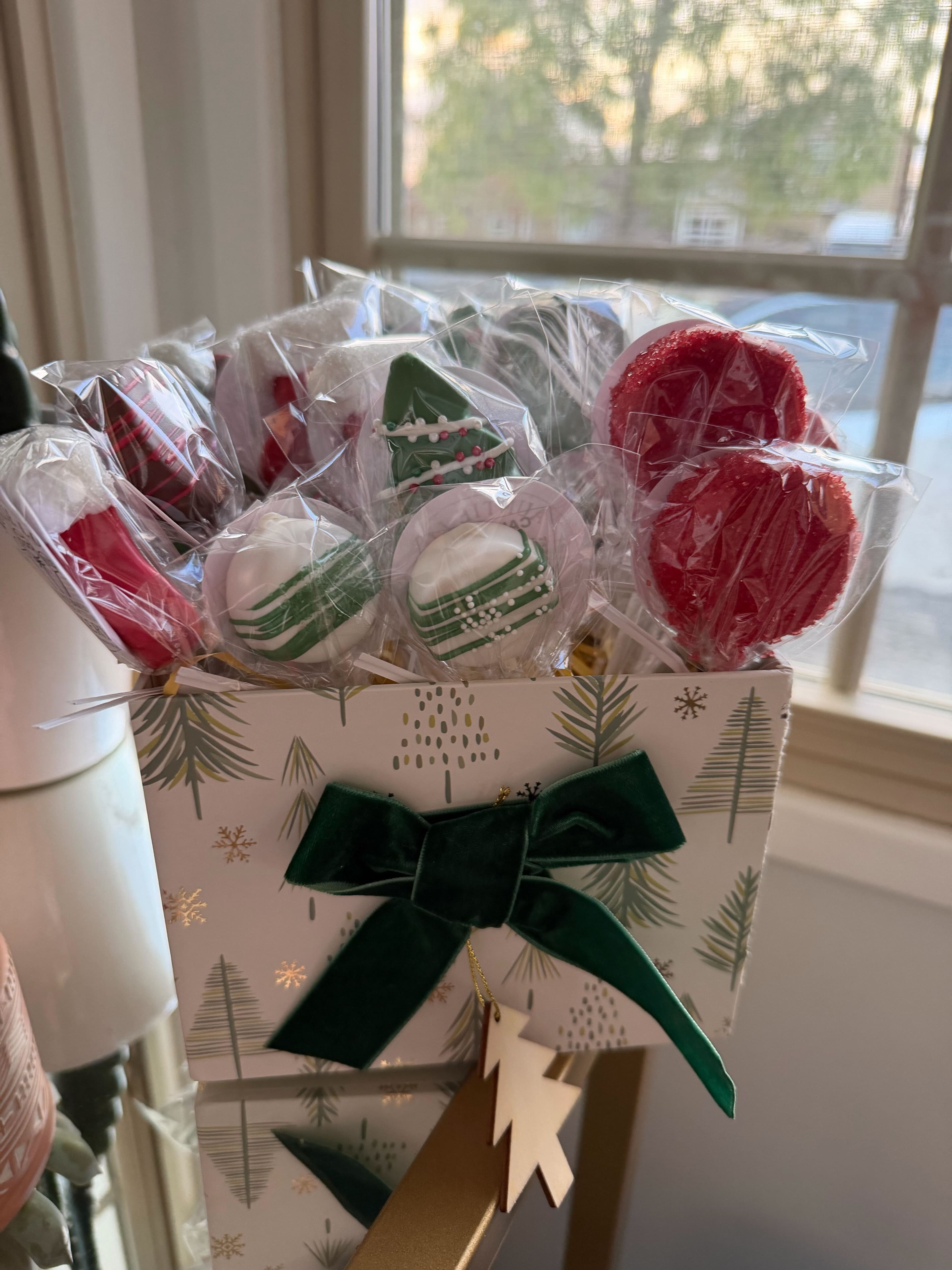 Cellophane-wrapped holiday cake pop gift sets with festive ribbons