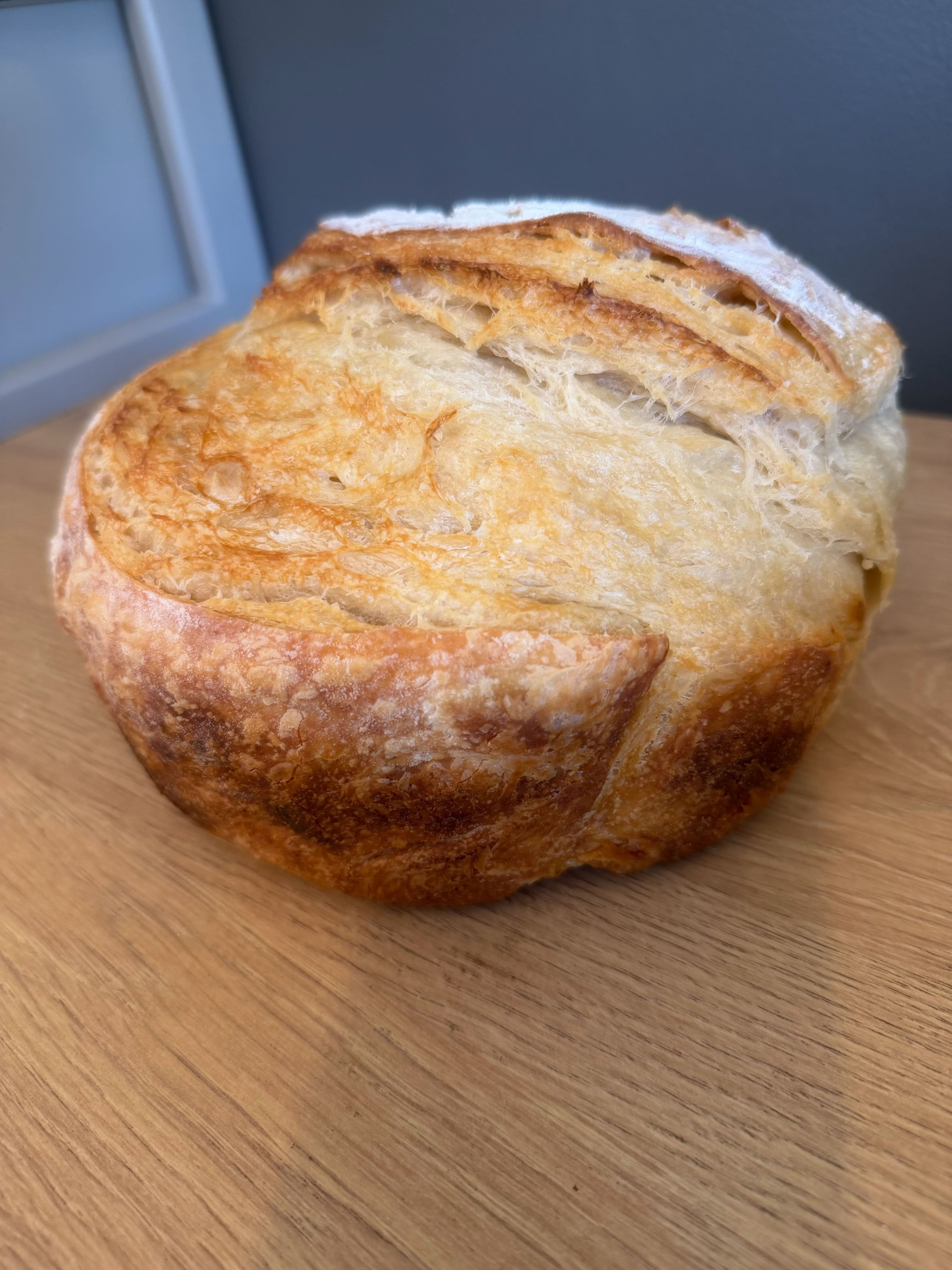 Golden-brown round sourdough loaf fresh from the oven
