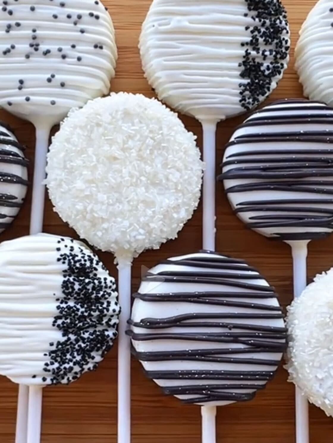 Elegant black-and-white cake pops with chocolate drizzle and sugar sprinkles