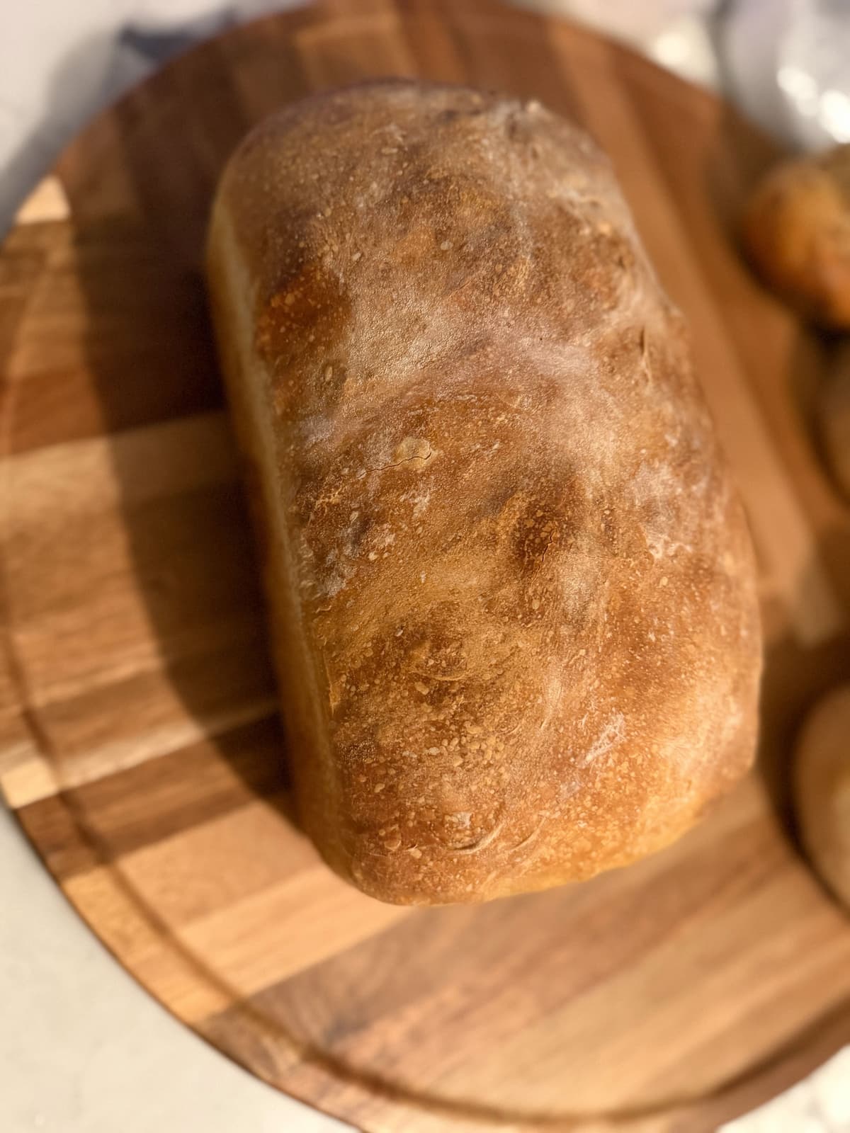 Rustic ciabatta loaf with a golden crust on a wooden board
